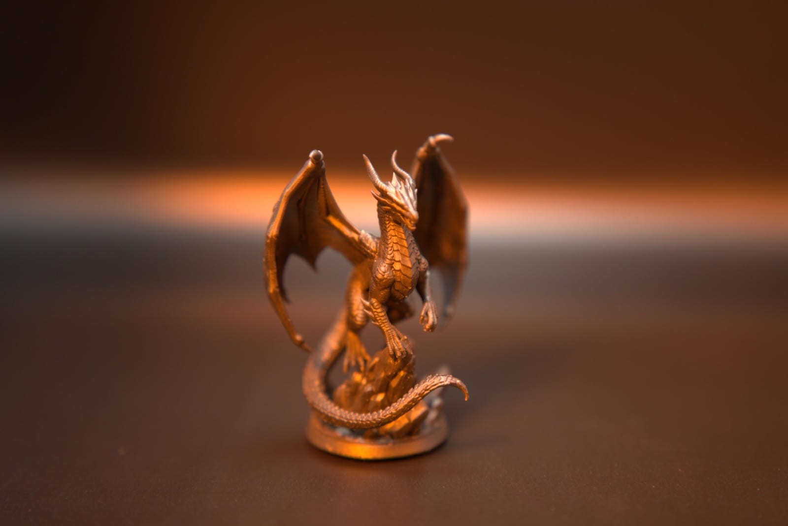 Copper-finished resin dragon miniature with individual scales, standing on its crystal base