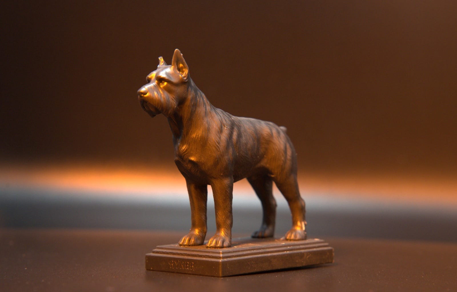 Copper-finished pet portrait figurine of a schnauzer, the name Ryker engraved in its base