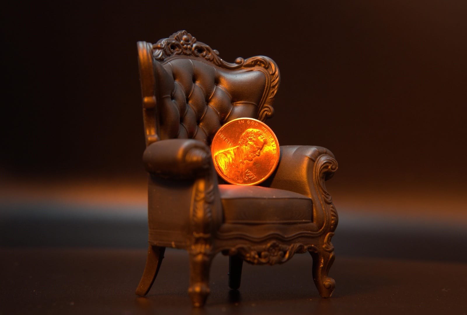 The miniature armchair with a penny resting on its seat for scale