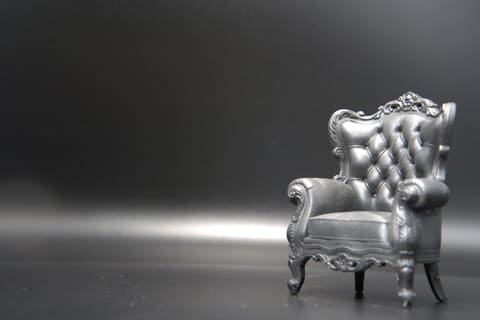 1:12 scale resin-printed tufted wingback armchair against a grey backdrop