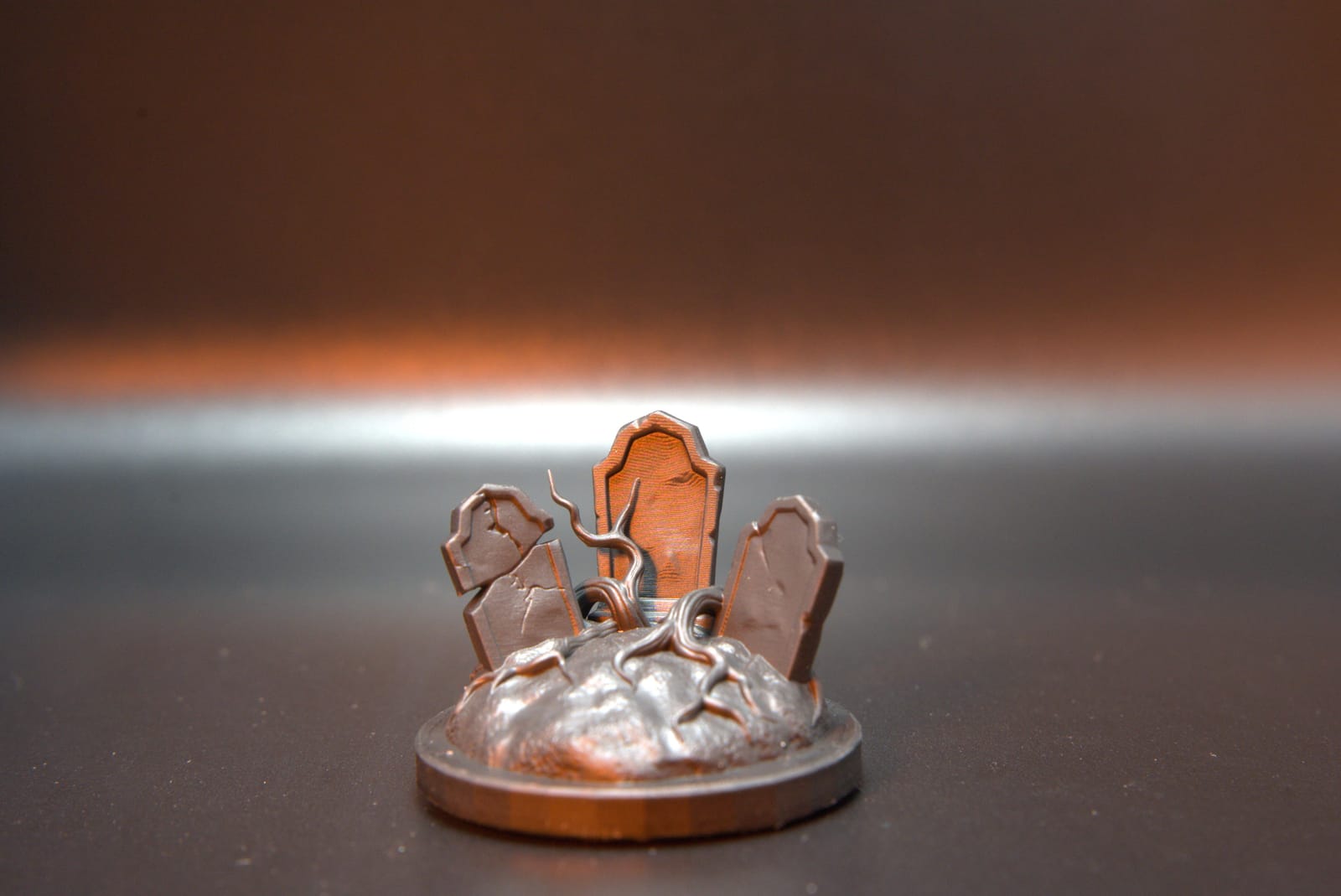 The same graveyard terrain base printed in grey resin, headstone and root detail intact